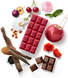 Red chocolate bar with various fruits, flowers, and spices on a white background